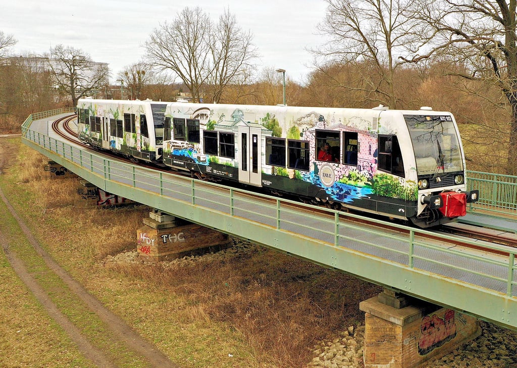 Ein neu erworbener Triebwagen der Dessau-Wörlitzer Eisenbahn ist auf der Muldebrücke unterwegs. In Waldersee sind Anwohner genervt, wenn die Bahn sich bei der Ortsdurchfahrt mit Hupen bemerkbar macht.