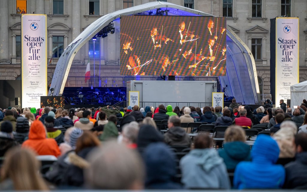 Zahlreiche Zuschauer verfolgen auf dem Bebelplatz die Live-Opernübertragung von Mozarts „Le nozze di Figaro“.