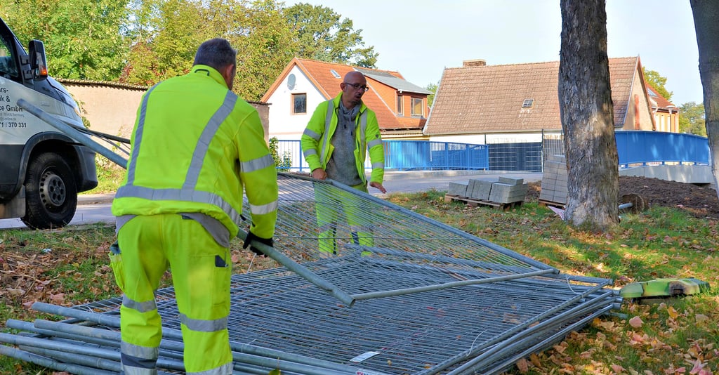 Mitarbeiter einer Verkehrstechnik-Firma beräumen am Freitag die beiseite gelegten Absperrungen und an den Straßenrand gerückten Umleitungsschilder vom Bau der Wipperbrücke in Osmarsleben. Foto: Falk Rockmann