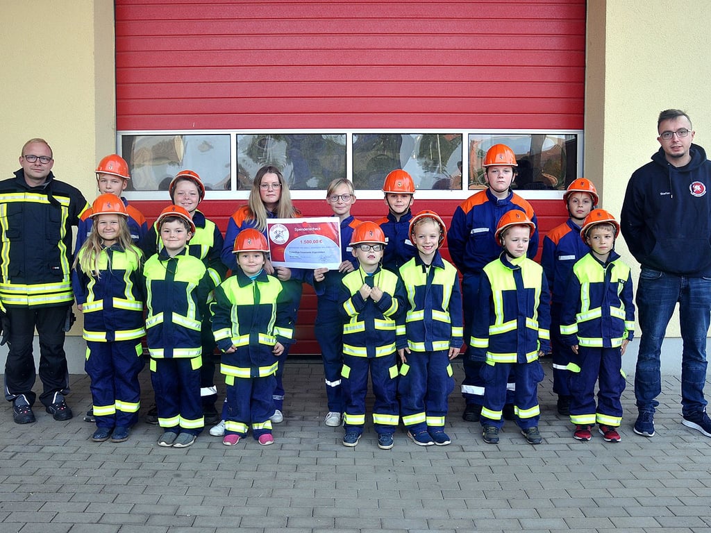 Die jüngsten Etgerslebener Feuerwehrleute der Kinder- und Jugendwehr, hier mit dem stellvertretenden Jugendwart Stefan Richter (r.) und Marcel Lehnardt, mit dem Spendenscheck.
