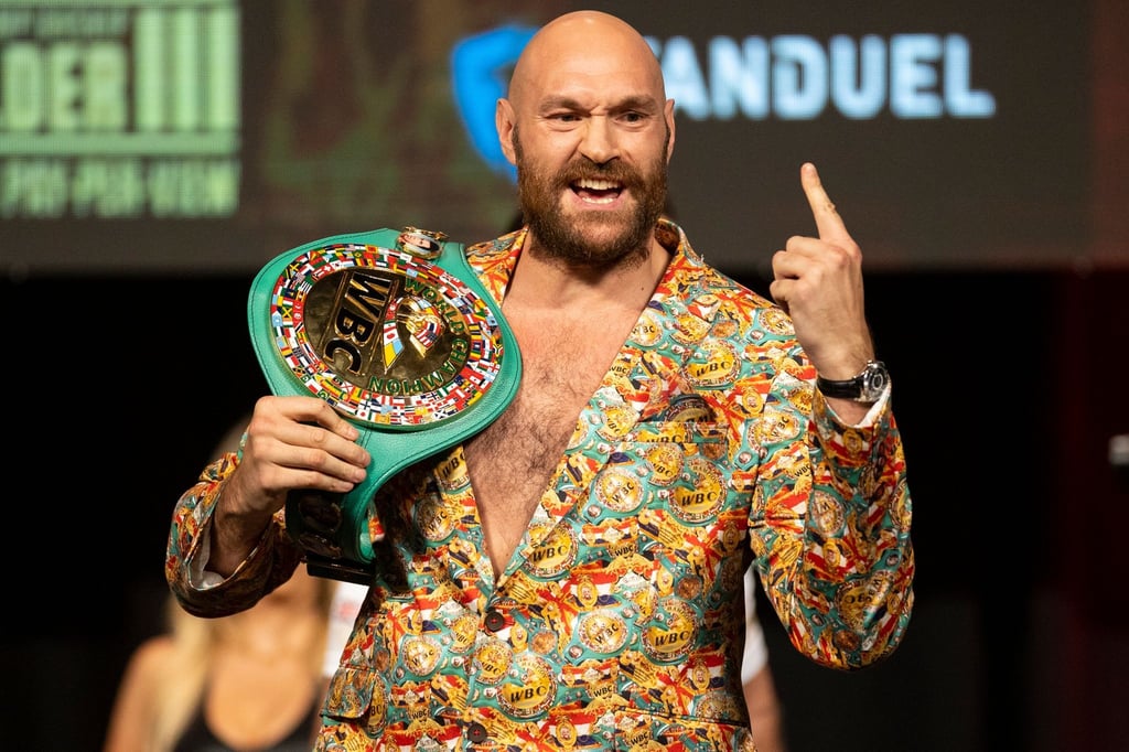 Muss erneut gegen Deontay Wilder ran: Tyson Fury gestikuliert bei einer Pressekonferenz mit seinem Gürtel.
