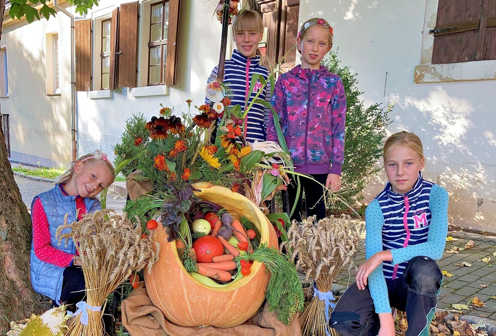 Die Kinder der Langendorfer Solawi präsentieren einen Teil der Ernteerträge des Vereins.