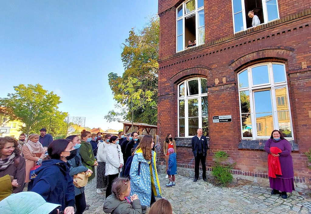 Im Beisein einiger Schüler und Eltern enthüllen Anja Grabmann und Marcus Brockhaus (unten v.r.) das Schild.