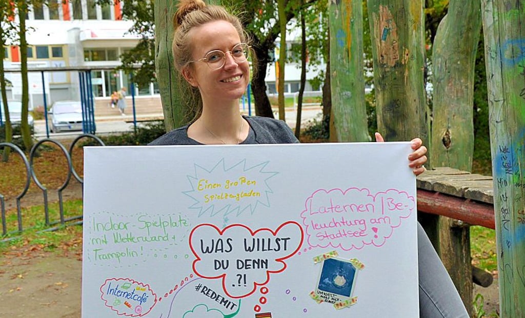 Janine Kaminski präsentiert ein selbsterstelltes Plakat einiger Kinder mit ihren Wünschen für Stendal.