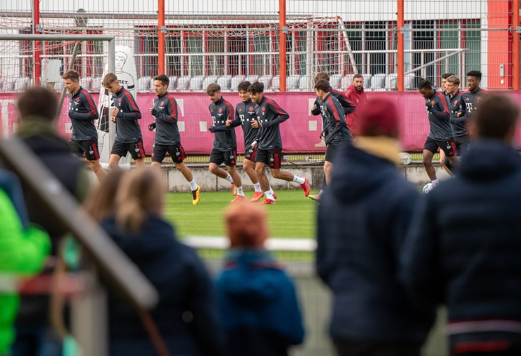 Nach langer Zeit wieder ein öffentliches Training: Spieler und Trainer des FC Bayern München laufen sich vor anwesenden Fans warm.