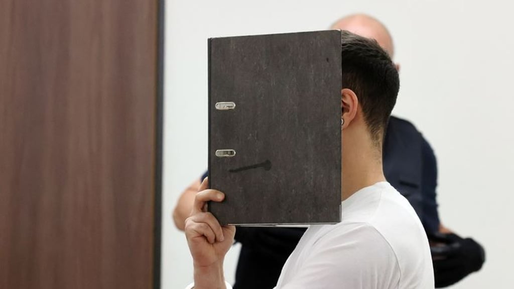 Der Angeklagte wird in Handfesseln in den Verhandlungssaal des Landgerichtes geführt. Der Mann ist im Prozess wegen schweren sexuellen Missbrauchs von Kindern angeklagt. Foto: Bodo Schackow/