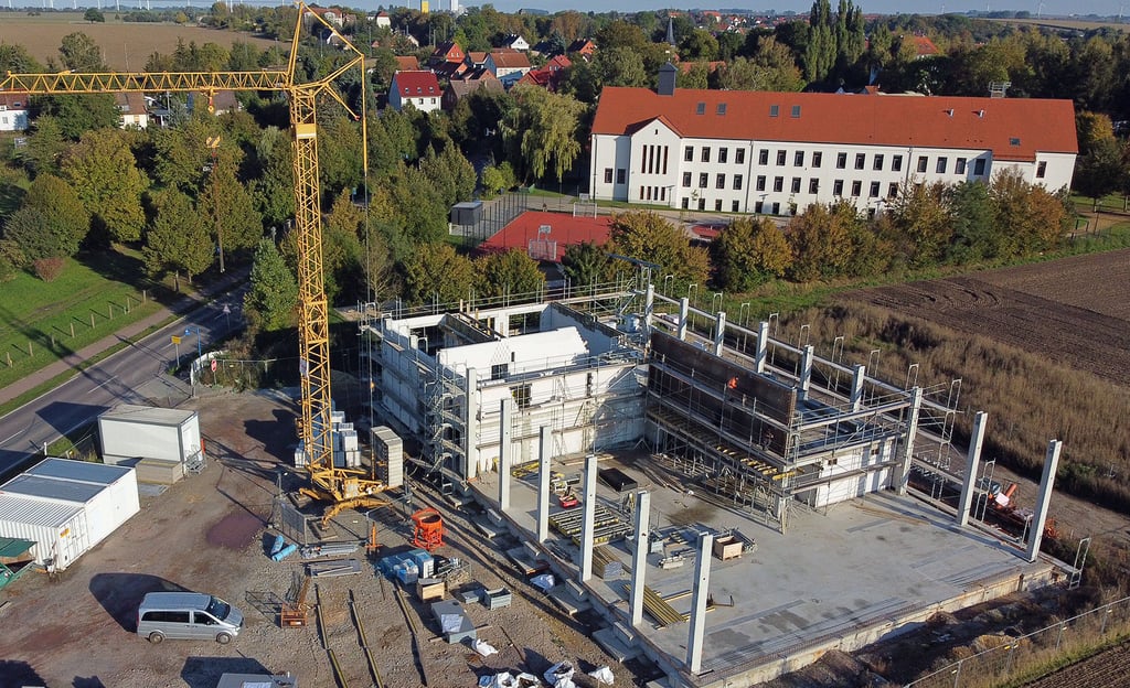 Blick von oben auf die Baustelle am Ortseingang Ummendorfer Straße. Schon gut erkennbar ist die Teilung zwischen der Fahrzeughalle und dem zweigeschossigen Diensträume- und Sanitärbereich.