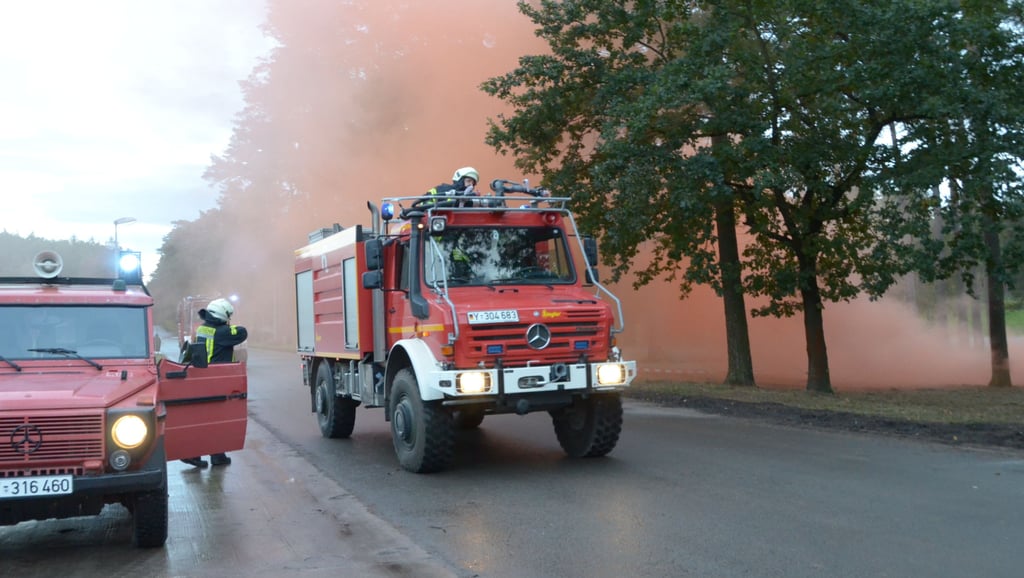 Die Berufsfeuerwehr des Übungsplatzes demonstrierte die Bekämpfung eines Waldbrandes. Der Qualm stammt von einem Rauchtopf, dank des Megafons konnten die Gäste dem Einsatzleiter bei der Befehlsgebung zuhören.
