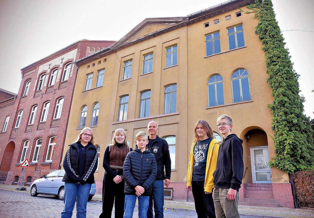 Ferenc Makk (3.v.re.) erklärt den Schülern, dass anstelle des Gebäudes hinter ihnen die neue Mehrzweckhalle entstehen soll.