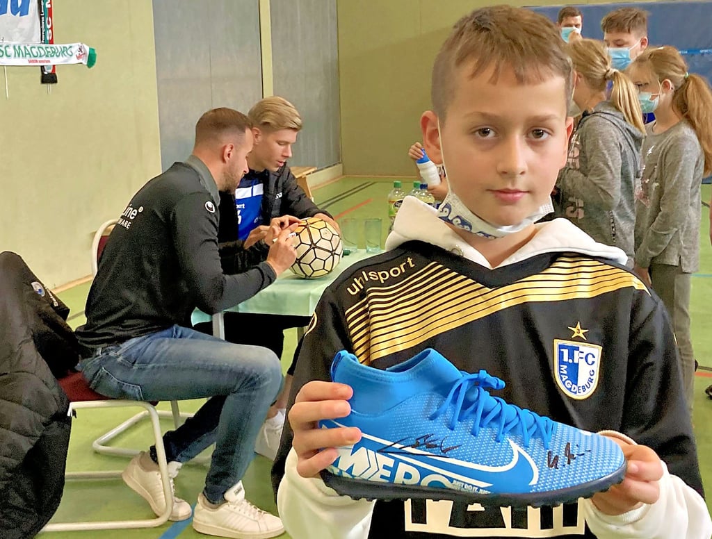 Tayler würde gern in die Fußstapfen der Spieler des FCM treten. Am Mittwoch nutzte er den Besuch von Co-Trainer Matthias Mincu und Stürmer Jan Luca Schuler, um sich Autogramme zu sichern.