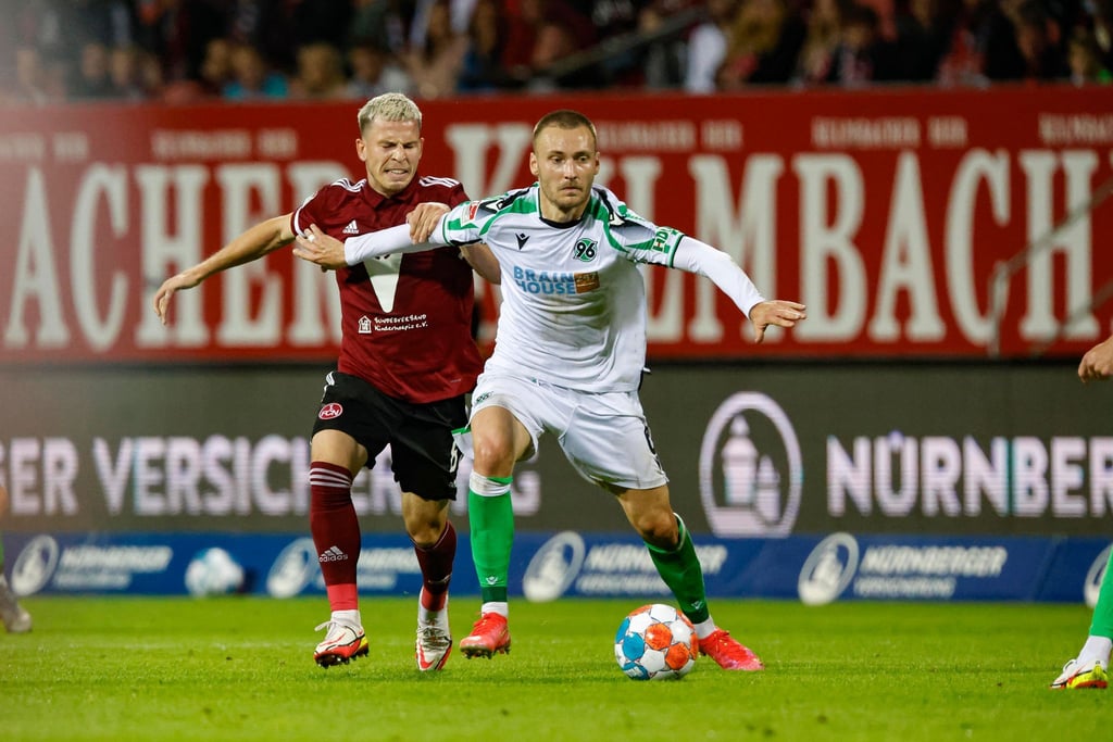 Hannovers Tom Trybull (r) schirmt den Ball vor dem Nürnberger Lino Tempelmann (l) ab.