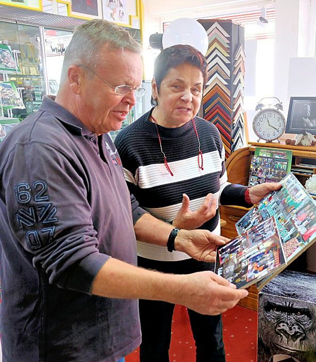 Angelika und Detlef Wimmer schauen sich alte Bilder an.
