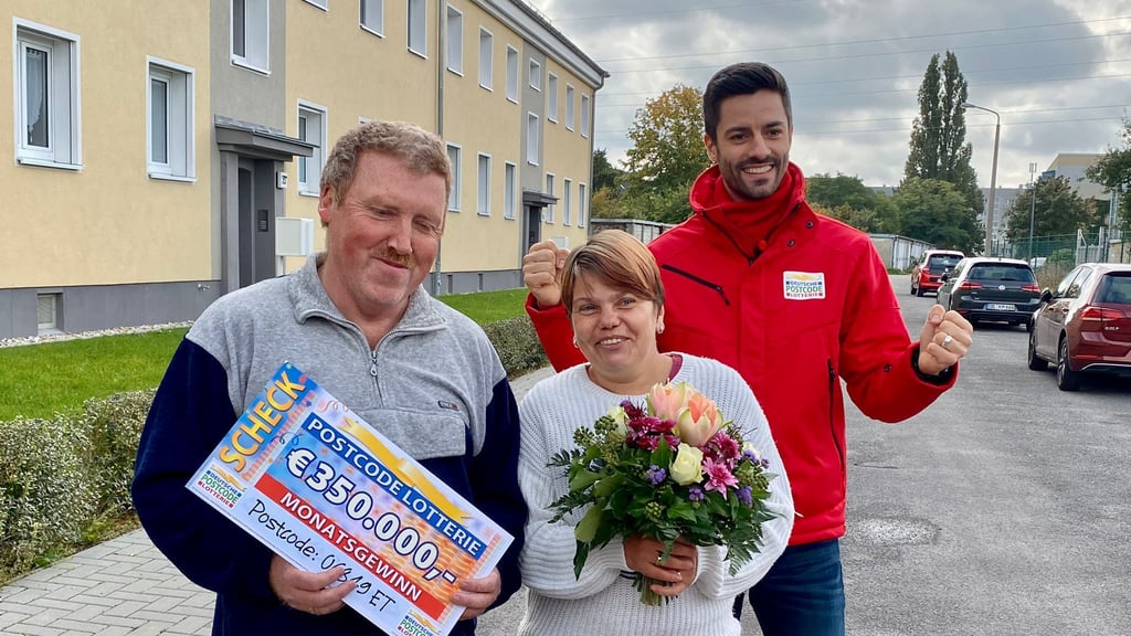 Moderator Giuliano Lenz (r.) von der Postcode-Lotterie überreichte dem frisch gebackenen Ehepaar den Scheck