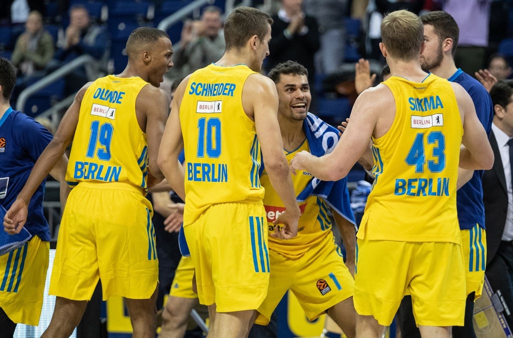 Louis Olinde (l-r), Tim Schneider, Oscar da Silva und Luke Sikma jubeln nach einem Punktgewinn für Alba Berlin.