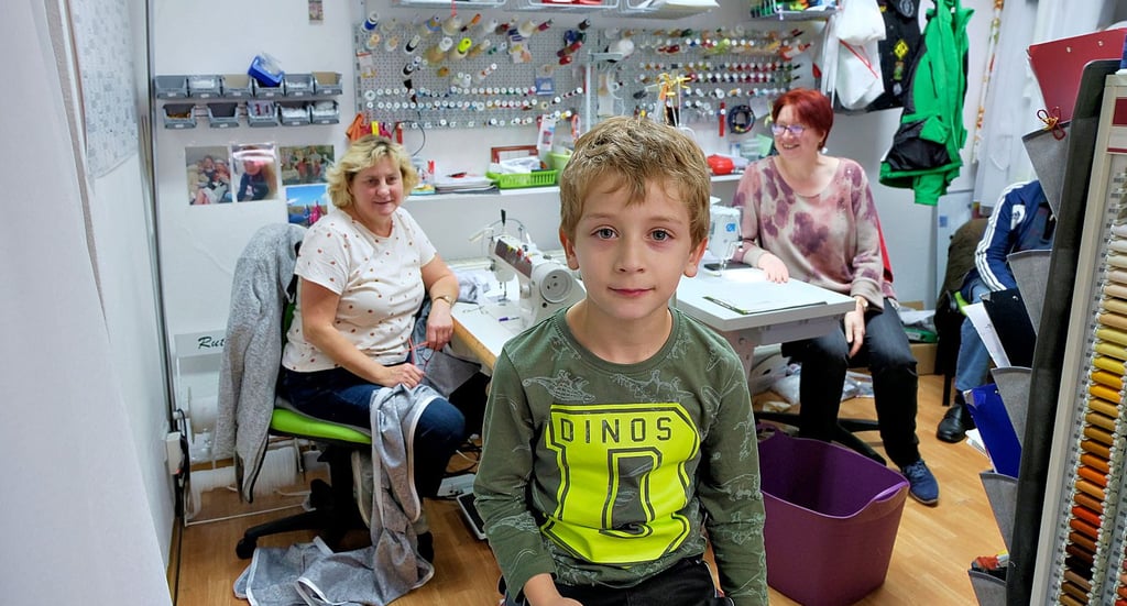 Der sechsjährige Alex aus Darmstadt besucht seine Oma (im Hintergrund links), die in der Stick- und Gardinenstube von Anke Müller arbeitet.
