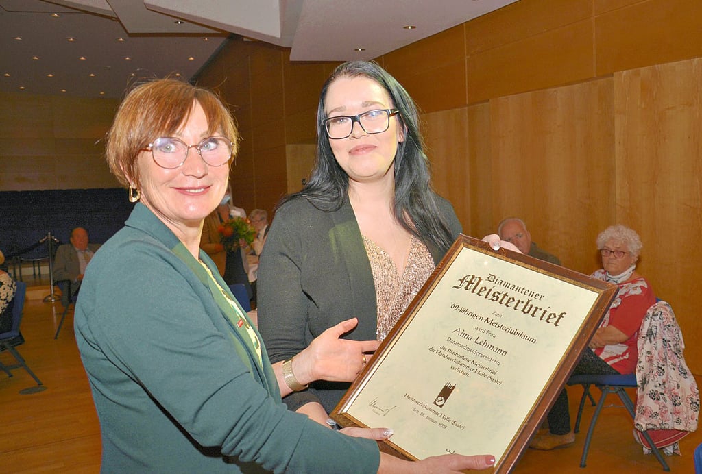 Angelina Lehmann (re.) nimmt stellvertretend für ihre Oma Alma Lehmann die diamantene Meisterurkunde aus den Händen von Bettina Pfeiffer, Vorstandsmitglied der Handwerkskammer Halle, entgegen.