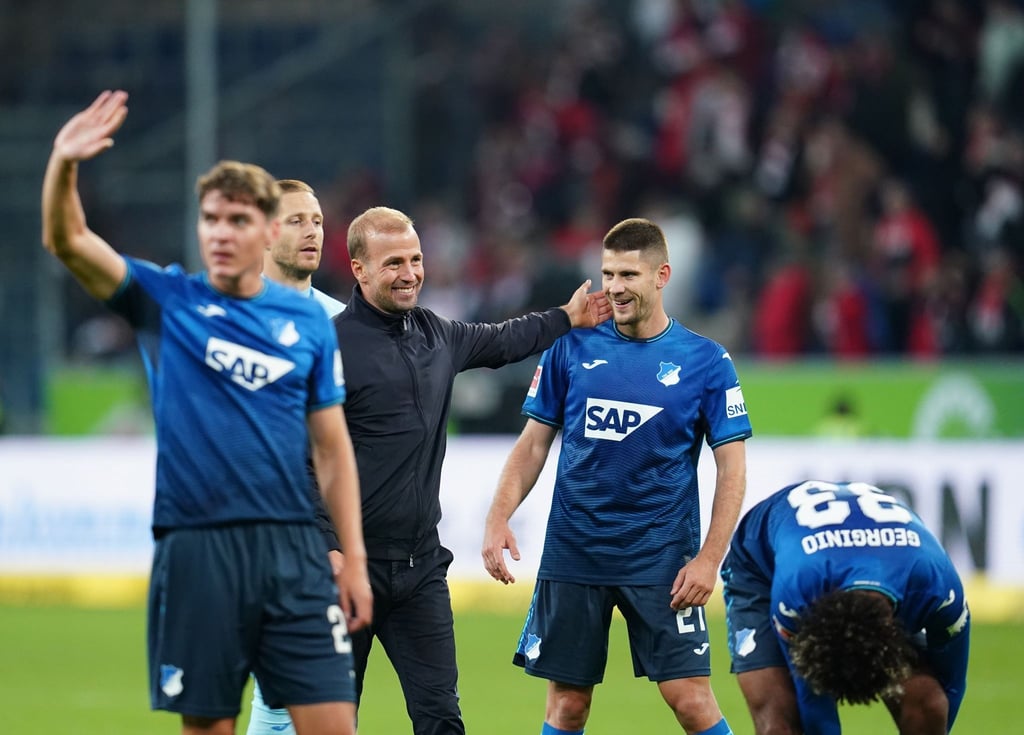 Hoffenheims Robert Skov, Trainer Sebastian Hoeneß, Benjamin Hübner und Georginio Rutter (l-r) feiern nach der Partie.
