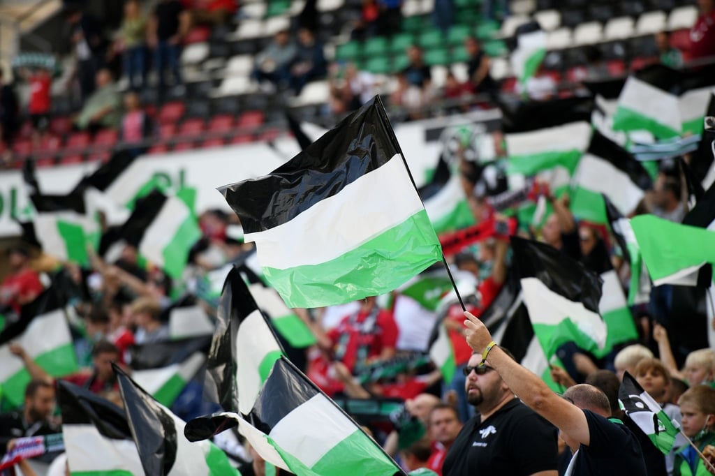 Hannover 96 hofft auf ein wieder voll ausgelastetes Stadion: Fans schwenken Fahnen.