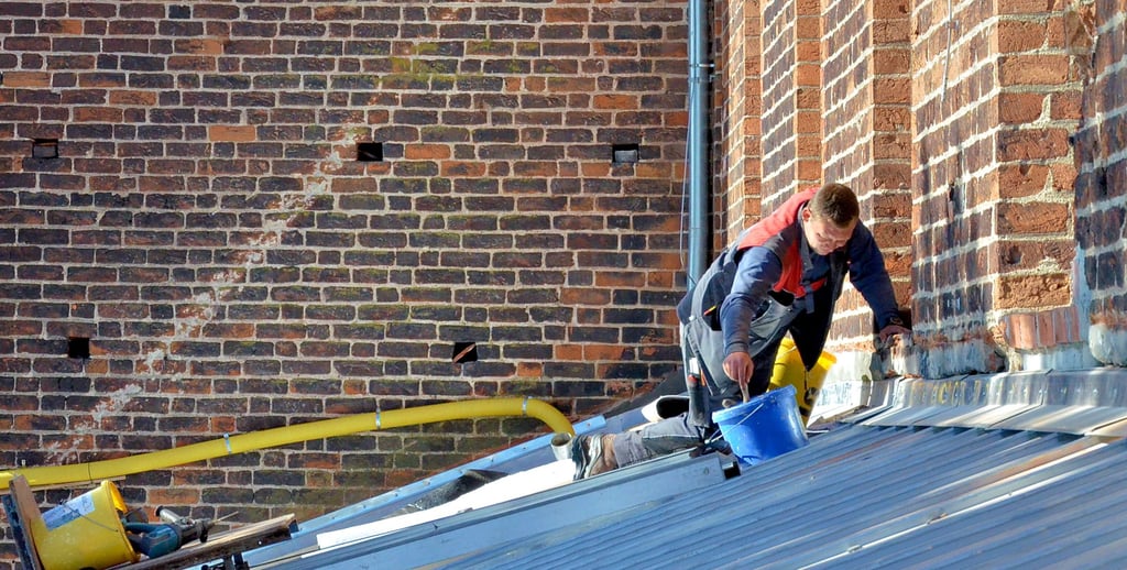 Dachdecker Marcus Gehrandt verfugt den Anschluss des neuen Daches an die Fassade des Hauptschiffes mit Mörtel. Dieser ist zwar faserverstärkt, dennoch werden irgendwann Spannungsrisse auftreten.