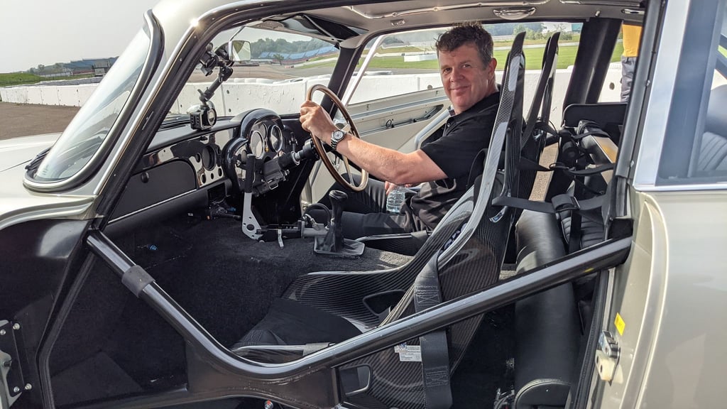 Mark Higgins in einem Aston Martin DB5 Stuntfahrzeug.