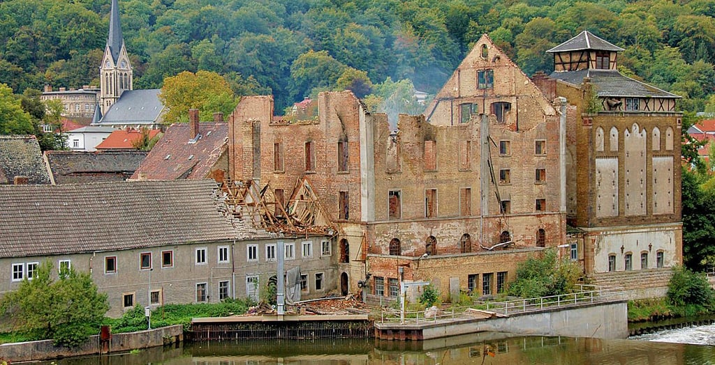 Die alte Mühle brannte bei einem Feuer im September 2017 komplett aus. Daran angebaut, ist noch das frühere Kraftwerksgebäude zu sehen.