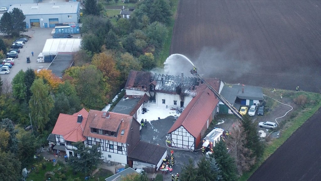 Die Feuerwehrleute kämpfen darum, dass das Feuer nicht auf das Wohnhaus übergreift.