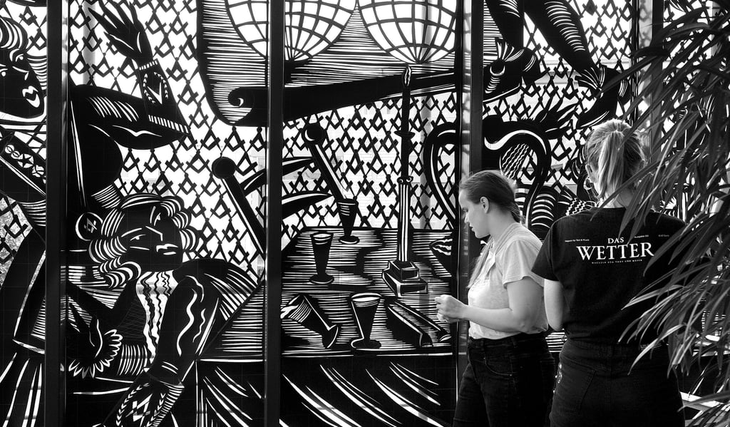 Die Künstlerin Sonja Yakovleva (2. von rechts) hat  an den vergangenen Tagen ihren großformatigen Scherenschnitt in eines der Hoffenster der Stendaler Kreissparkasse an der Poststraße geklebt. Das Fenster wird von innen beleuchtet.