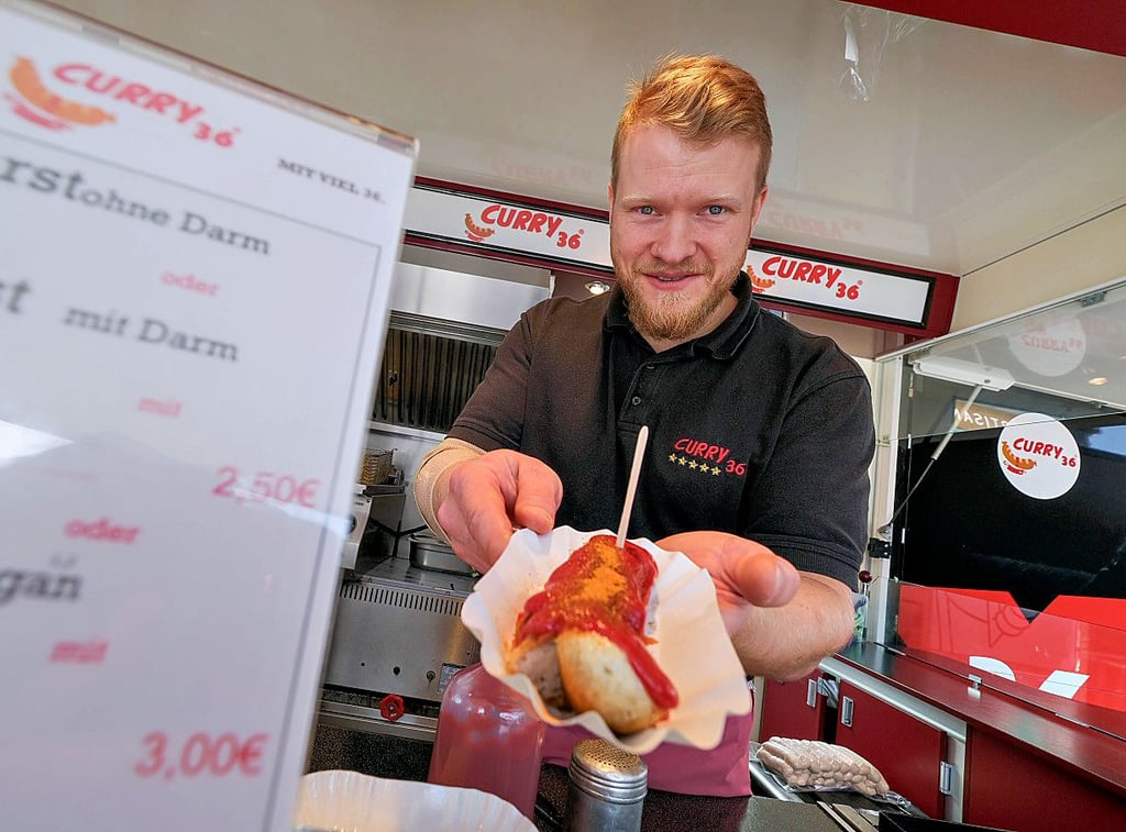 Currywurst ala Berlin verkauft Steve Kaufmann auf dem unteren Markt.