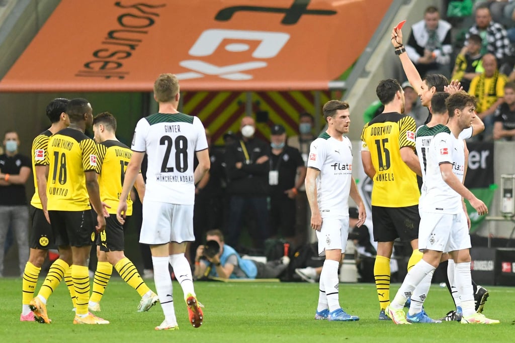 Schiedsrichter Deniz Aytekin (3.v.r) stellt Dortmunds Mahmoud Dahoud (l) vom Platz.