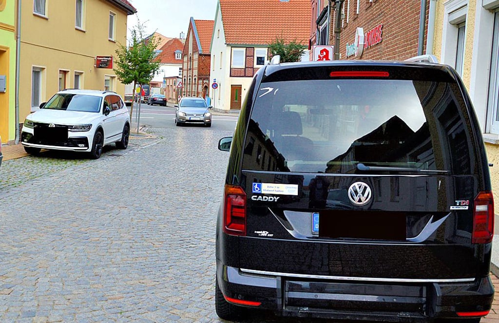 Weil der weiße Pkw auf der Ernst-Thälmann-Straße in Kalbe unberechtigter Weise auf dem Parkplatz für Behinderte stand, musste der Berechtigte gegenüber auf dem Gehweg parken.