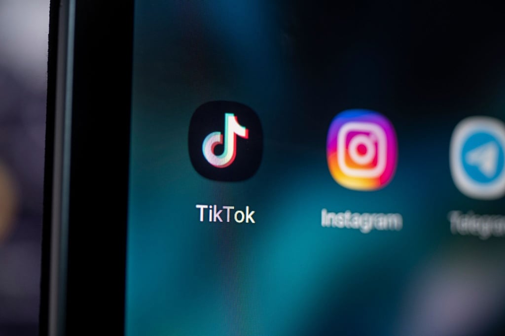 Auf dem Bildschirm eines Smartphones sieht man die Logos der Apps TikTok und Instagram.