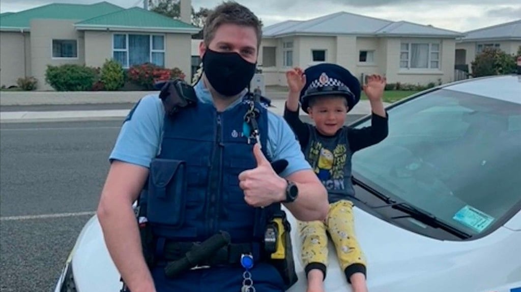 Auf diesem Foto, das die Polizei bei Instagram geteilt hat, sitzt Wachtmeister Kurt mit einem vierjährigen Jungen auf der Motorhaube seines Polizeiautos.