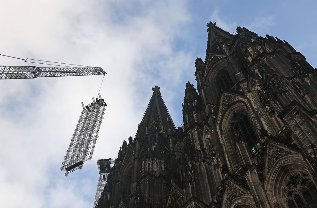 Ein Teil des Baugerüstes wird vor dem Dom heruntergelassen.