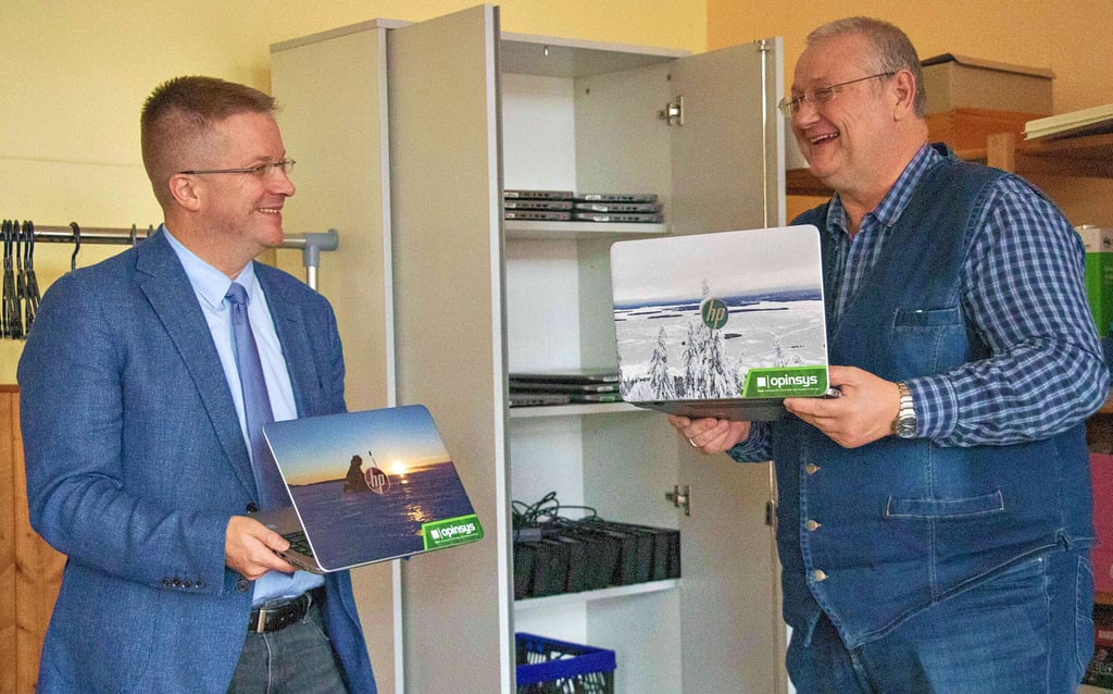Thales Bürgermeister Maik Zedschak (l.) und Schulleiter Mike Litschko betrachten die neuen Laptops.