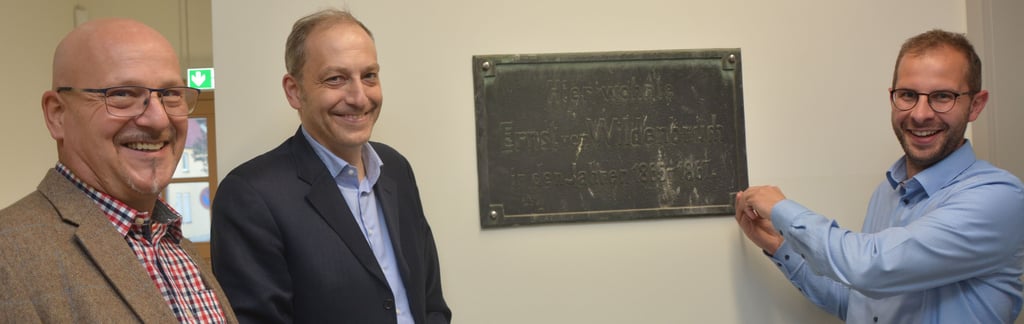 Bürgermeister Philipp Stark (r.), Ferdinand Kiderlen und Clemens Engel an der Gedenktafel für Ernst von Wildenbruch in der evangelischen Grundschule.