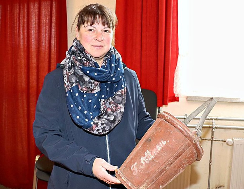 Jennifer Kissel zeigt den alten Löscheimer von Friedrich Altenau.