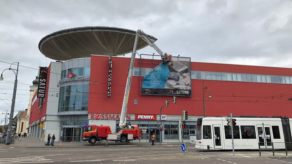 Feuerwehr am Dessau-Center: Ein Werbeplakat wird gesichert. 