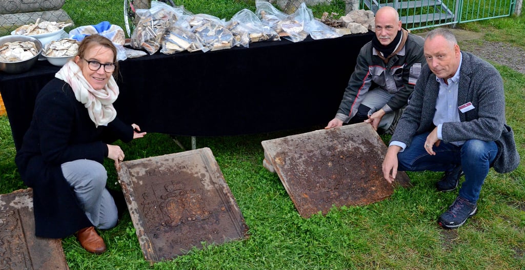 Dr. Dietlind Paddenberg, Gebietsreferentin des Landesamtes für Denkmalpflege und Archäologie (LDA), Grabungsleiter Frank Besener (rechts) und Enrico Groeschke, der ebenfalls an den Grabungen beteiligt war, präsentieren die drei gut erhaltenen gusseisernen Kaminplatten, die kleinere mit den Initialen von Katharinas Eltern.