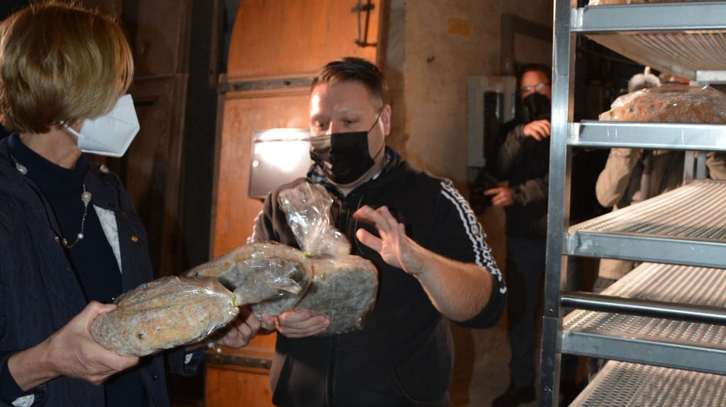 Dr. Uta-Christiane Bergemann, Direktorin des Domschatzes, reicht im Remterkeller des Halberstädter Doms Bäckermeister Peter Potratz Stolle zu.