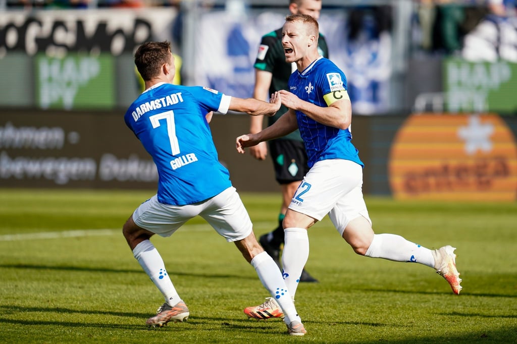 Darmstadts Torschütze Fabian Holland (r) jubelt mit Benjamin Goller über das Tor zum 1:0.