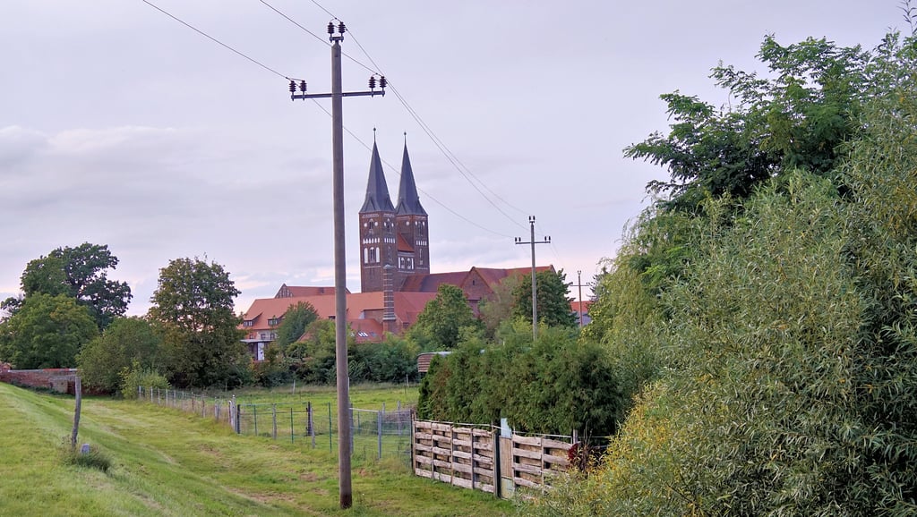 Die typischen Überlandleitungen, hier am Kloster Jerichow, brachten die Elektrizität auf das Land. Damit veränderten sich die Lebens- und Arbeitsgewohnheiten nachhaltig. Die Helligkeit des Tages spielte keine Rolle mehr.