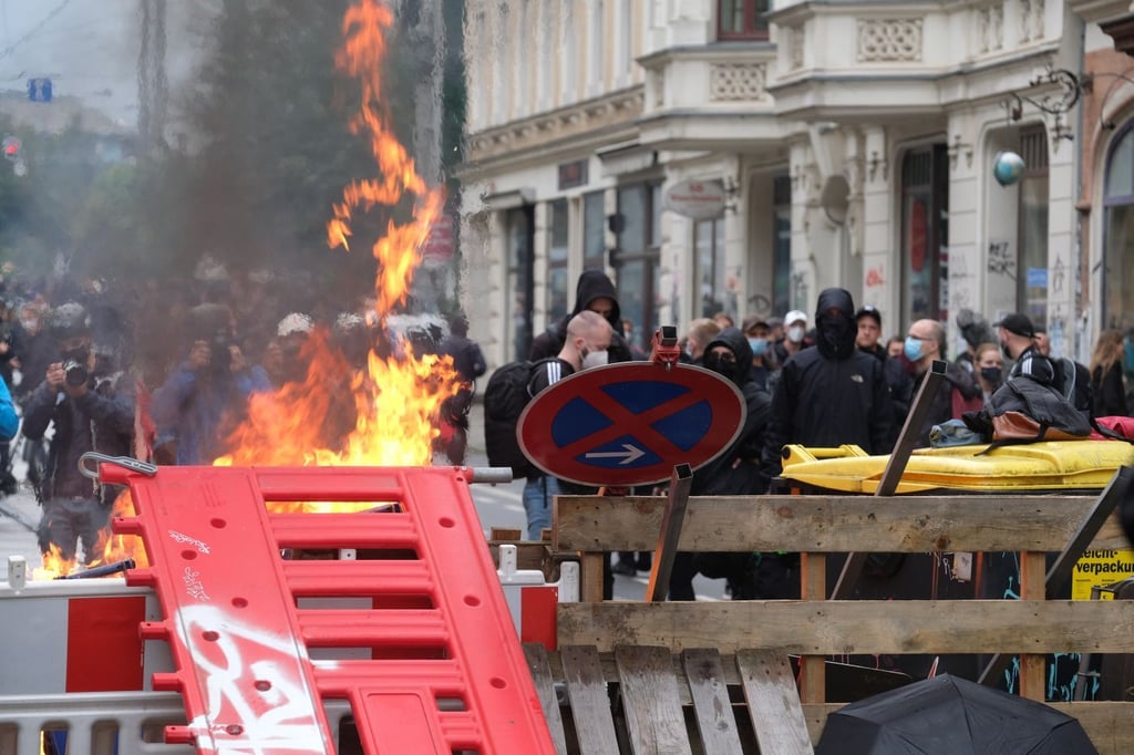 Maskierte Teilnehmer stehen im September 2019 hinter einer Barrikade. Im Leipziger Stadtteil Connewitz wurden damals auch Barrikaden errichtet und angezündet.