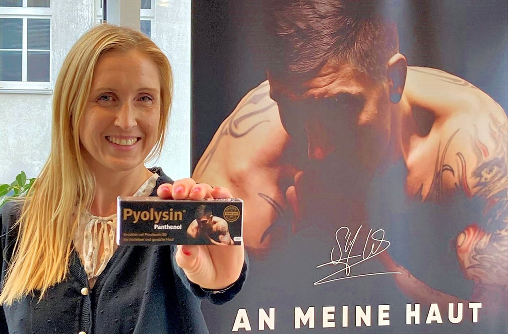 Marketingleiterin Kati Schulze zeigt die neue Hautpflegecreme Pyolysin Panthenol des Serumwerks Bernburg, für die Tattoo- und Handballstar Stefan Kretzschmar wirbt.