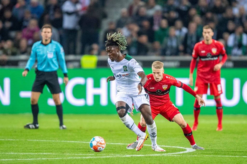 Gladbachs Kouadio Kone (l) und Stuttgarts Chris Führich kämpfen um den Ball.