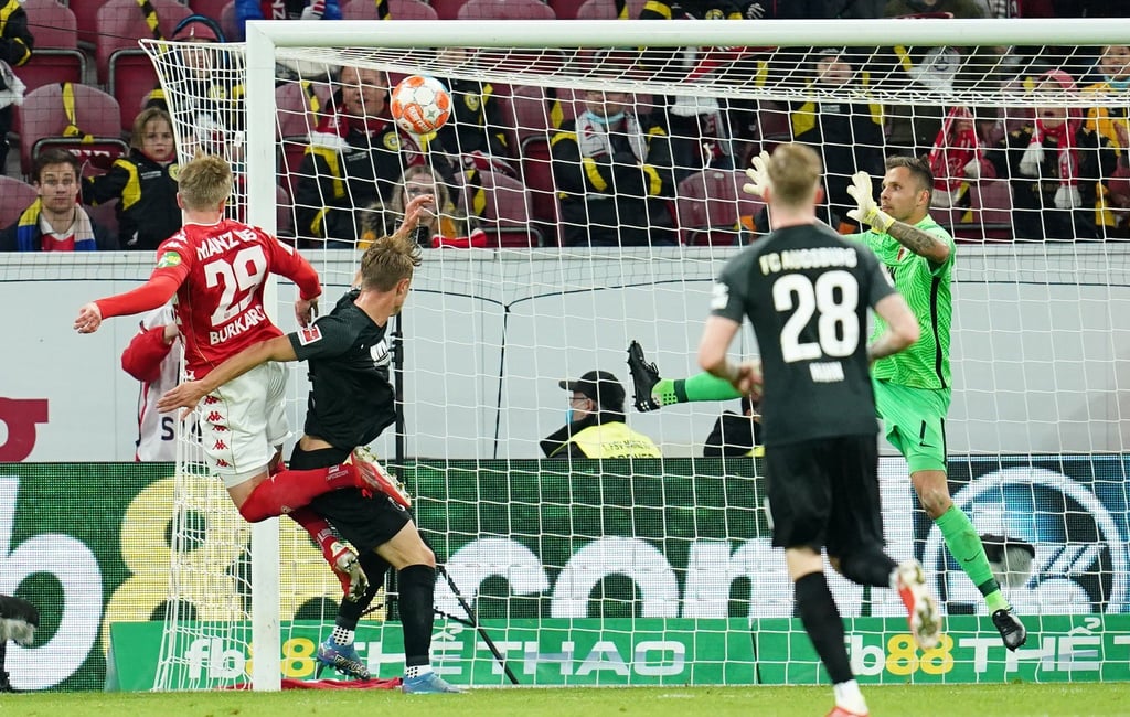 Jonathan Burkardt (l) köpft den Ball zum 3:0 ins Tor von Augsburgs Torwart Rafal Gikiewicz (r).