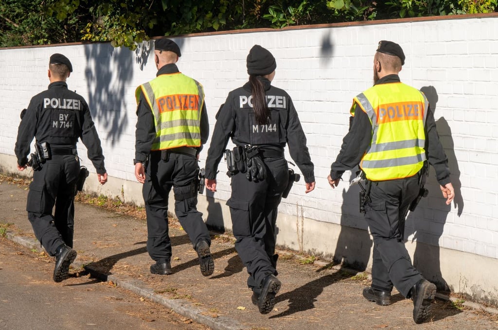 Polizisten gehen im Münchner Stadtbezirk Bogenhausen auf einer Straße entlang. Hier ist ein 14-jähriges Mädchen tot aufgefunden worden.