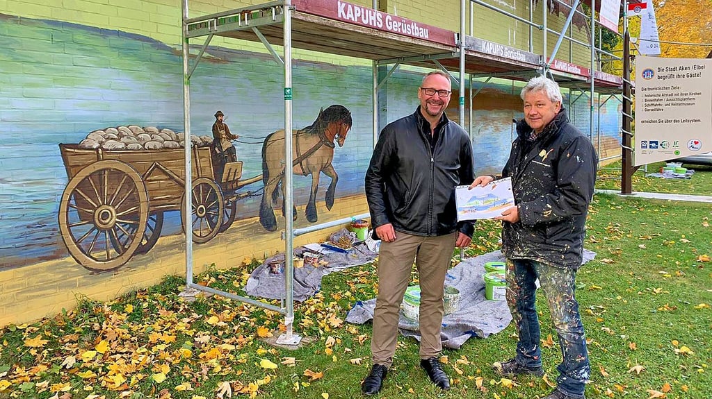 Bürgermeister Jan-Hendrik Bahn (links) und Künstler Steffen Rogge vor der halbfertigen Wand.
