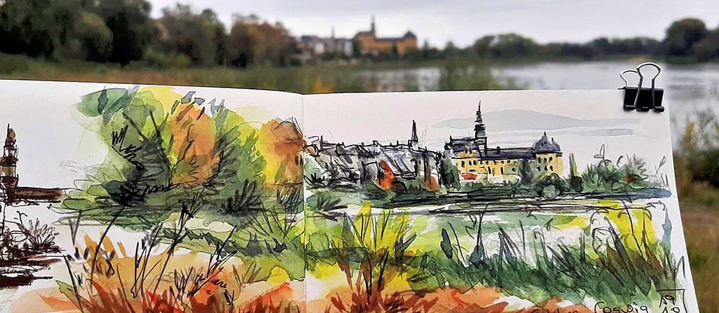 Das Schloss Coswig am Elbufer im Urban Sketching Stil, mit Original im Hintergrund, von Kristin Kuchenbecker.