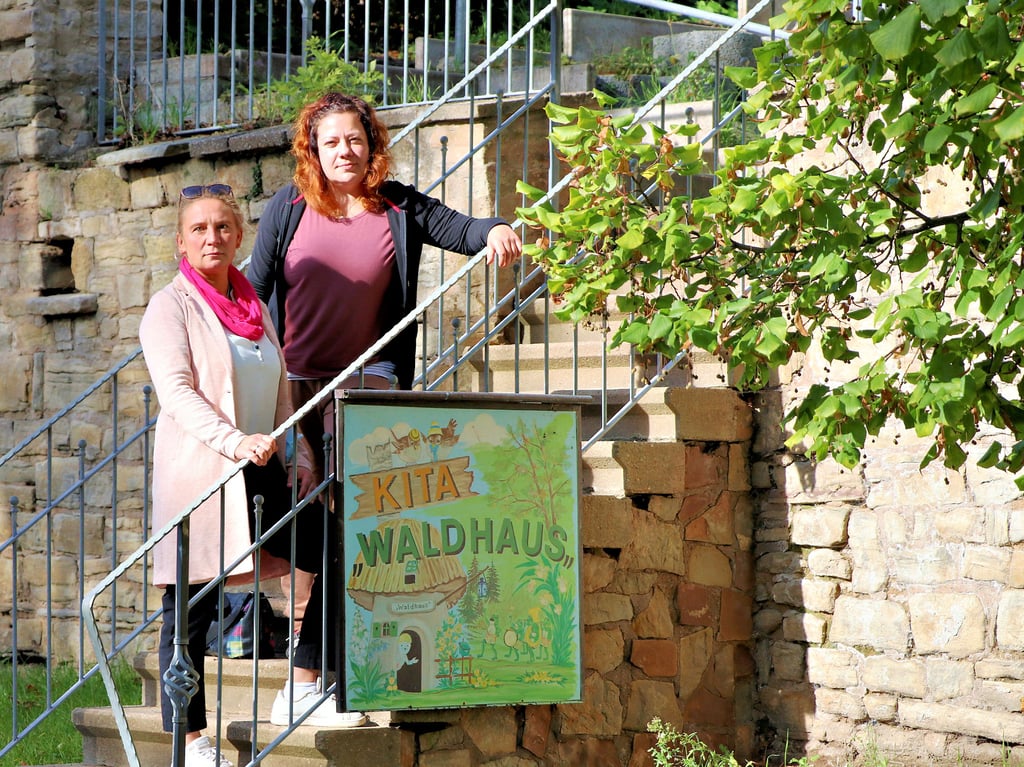 Ramona Prudlik (links), ehemalige Vorsitzende des Fördervereins Zorbau, und Lisa Birkner, Einrichtungsleiterin in Dehlitz, stehen am Aufgang zur Kita „Waldhaus“ in Dehlitz.