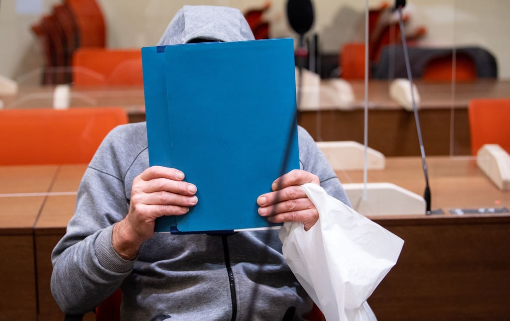 Der wegen Mordes durch Unterlassen angeklagte Mann sitzt vor Prozessbeginn im Gerichtssaal.